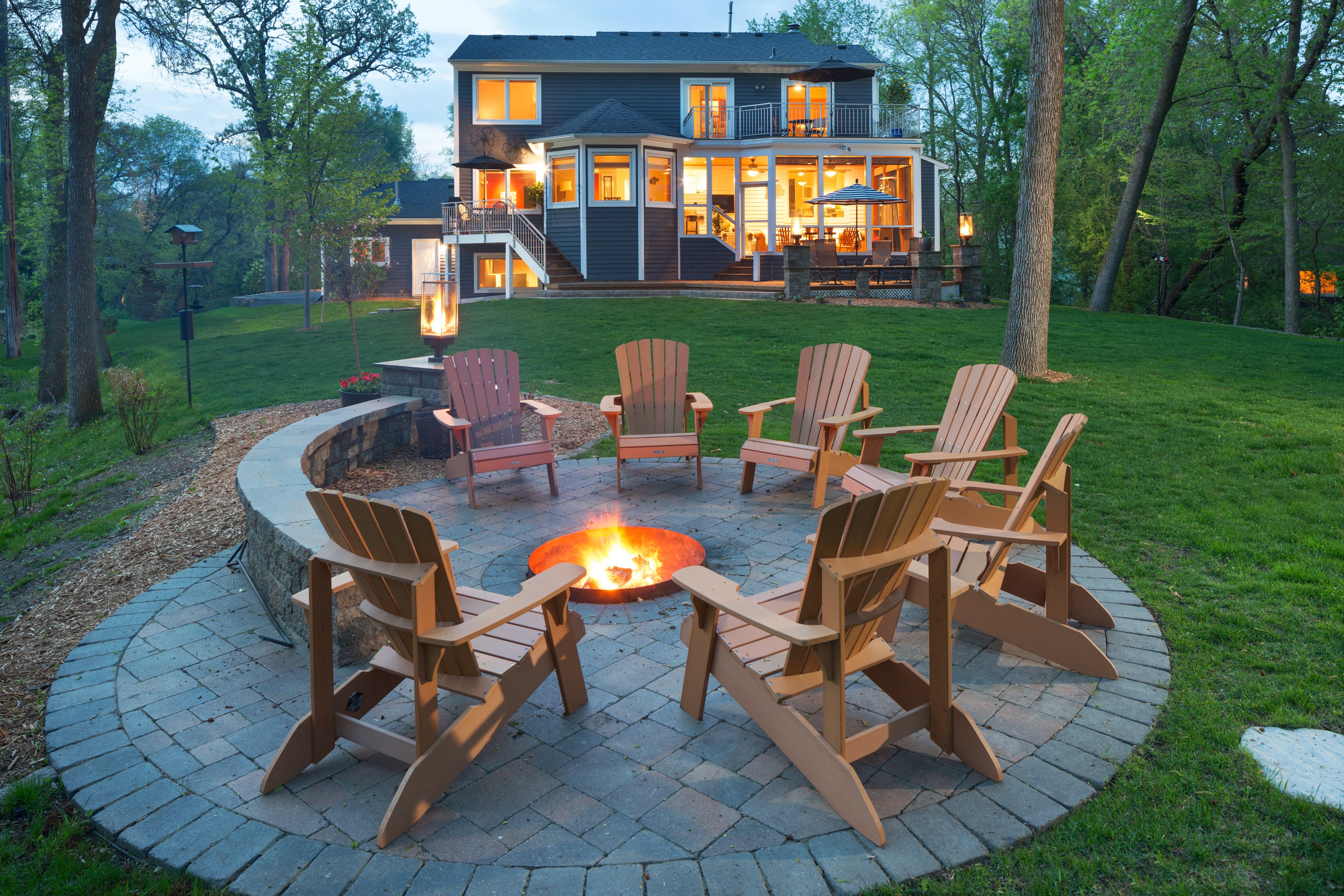 Eden Prairie home with a beautiful  backyard with bonfire fire pit and chairs around it.